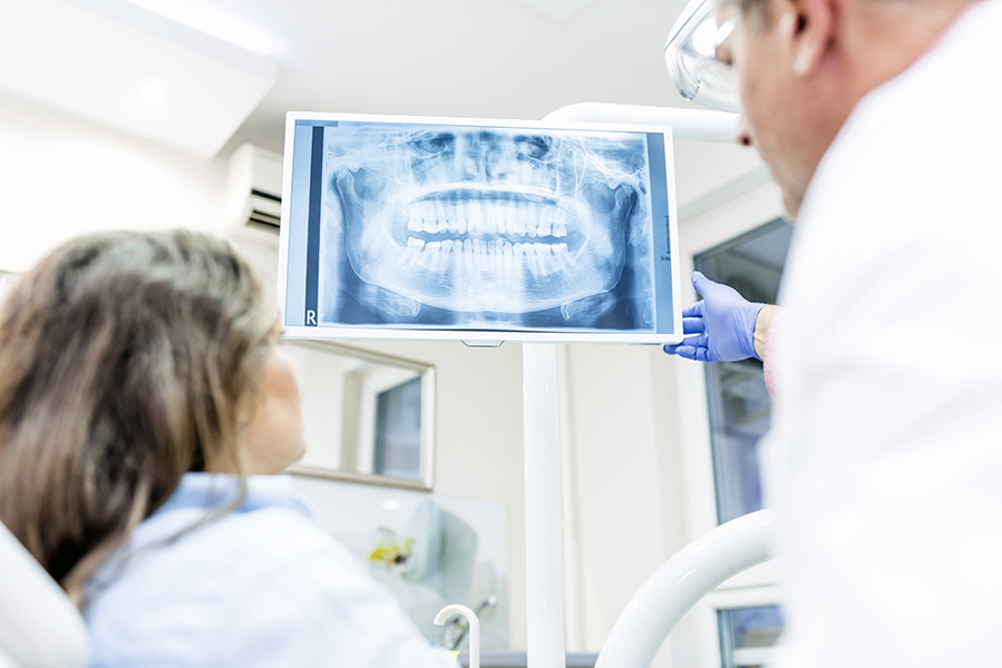 Photo of Dentist showing patient x-ray